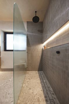 a bathroom with a glass shower door and tiled walls