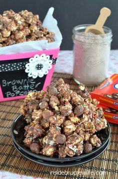 there is a bowl full of chocolate popcorn and some candy bars on the table next to it