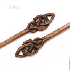 two wooden spoons with intricate designs on them