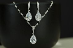 This elegant bridal set comes with white Cubic Zirconia Tear Drops Earrings and Necklace.The necklace is made of rhodium plated 10x17 mm (including the loop) rhodium plated cubic zirconia teardrops and finished with rhodium plated cubic zirconia bail.The pendant hangs on a sterling silver chain.Available sizes for the necklace are from 16 to 19 inches length. The earrings are made of rhodium plated over 925 sterling silver cubic zirconia earwires, and finished with 10x17 mm (including the loop) Classic Sterling Silver Jewelry Sets For Wedding, Silver Drop Jewelry Sets For Wedding, Silver Teardrop Pendant Jewelry Set For Formal Occasions, Wedding Jewelry Sets With Cubic Zirconia In Drop Shape, Elegant Silver Teardrop Pendant Jewelry Set, Silver Pear-shaped Jewelry Sets For Wedding, White Drop Bridal Necklace Cubic Zirconia, White Cubic Zirconia Drop Bridal Necklace, Classic Silver Teardrop Jewelry Sets