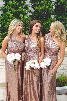 three beautiful women standing next to each other in long dresses with sequins on them