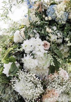 an arrangement of white and blue flowers