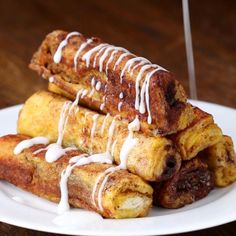 a white plate topped with cinnamon rolls covered in icing