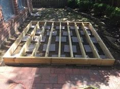 a wooden bed frame sitting in the middle of a yard