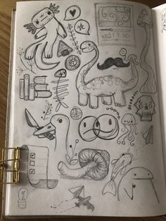 an open notebook with doodles and drawings on the pages, including animals and other things