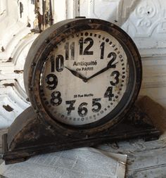 an old clock sitting on top of a table