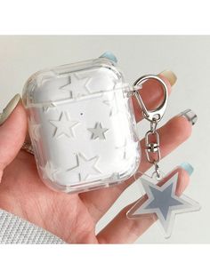 a hand holding an air freshener and keychain with stars on the front