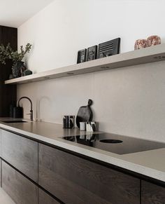 a modern kitchen with black and white accessories on the countertop, along with wooden cabinets