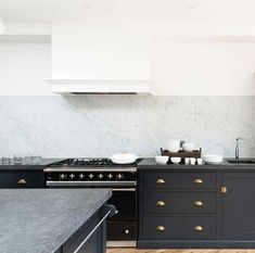 a kitchen with marble counter tops and black cabinets