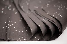 black and white photograph of fabric with silver dots on the top, in close up