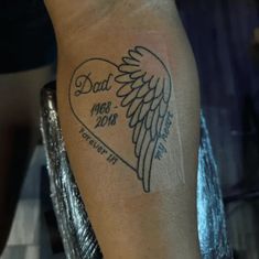 a man's arm with a tattoo on it that says dad and angel wings