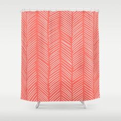 an orange and white shower curtain with arrows on the bottom, in front of a gray background