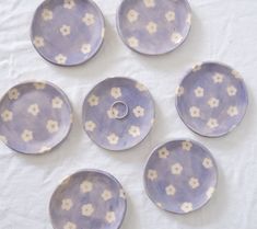 six purple and white plates with flowers on them