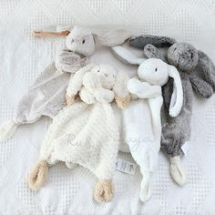 several stuffed animals laid out on a white blanket