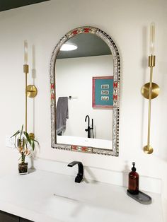 a bathroom with a sink, mirror and two faucets on the counter top