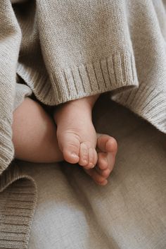 a baby's foot is tucked under a blanket