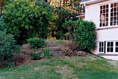 a house with steps leading up to the front door and trees in the back yard