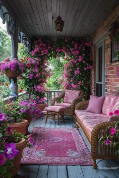 the porch is covered with pink flowers and wicker furniture, along with potted plants