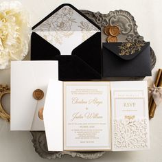 an assortment of wedding stationery and envelopes on a plate with flowers in the background