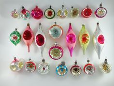 an assortment of christmas ornaments are displayed on a white surface