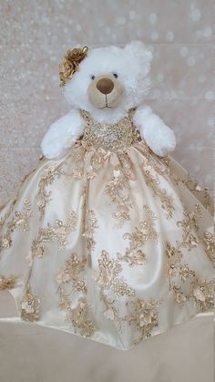 a white teddy bear wearing a gold dress