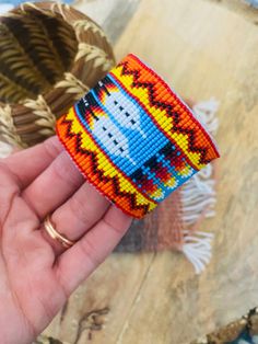 a hand holding a colorful beaded bracelet