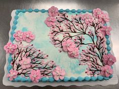 a cake decorated with pink flowers and blue icing