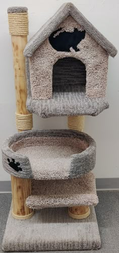 a cat tree with two cats in it's house and a scratching post attached to the top