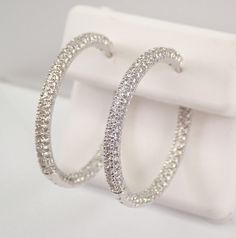 14K White Gold Diamond Hoop Earrings. These earrings are set with one hundred and eight genuine Round Brilliant Diamonds in EACH earring. These diamonds are H color, SI1 clarity and weigh a total of 1.75 carat. These earrings are 14K White Gold and weigh a total of 8.2 grams. These earrings are for pierced ears and measure 29 mm in diameter. These earrings will be accompanied by an appraisal written by a GIA Certified Diamond Grader with the retail replacement value of $4,895.00. I will ship these earrings promptly in a gift box. ADDITIONAL REQUESTS If you would like to see more pictures of this item, please let us know and we would be happy to provide them for you. Please contact us with all questions, we are here to help. Small Hoop Earrings In Diamond White With Pave Setting, Dazzling Pave Set Hoop Earrings For Anniversary, Formal Hoop Jewelry With Pave Setting, Dazzling Hoop Earrings With Pave Setting, Dazzling Small Hoop White Gold Earrings, Dazzling White Gold Small Hoop Earrings, Small Hoop Earrings With Pave Setting For Formal Occasions, Hoop Diamond Earrings With Vvs Clarity In Sterling Silver, Vvs Clarity Hoop Diamond Earrings In Sterling Silver