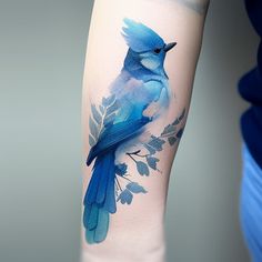 a blue bird with leaves on it's arm