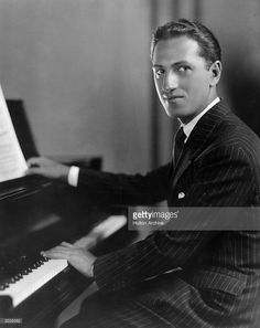 an old photo of a man sitting at a piano