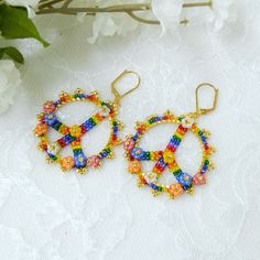 DIGITAL DOWNLOAD ONLY - does NOT include the actual earrings or materials. CALLING ALL HIPPIES!  Some of us grew up in the 60's & 70's & remember the days of FLOWER POWER and everything "groovy"!   The Peace Sign is universal, perpetual & easily recognized. These pretty earrings make an enduring statement.  You'll need 30mm circle links (available on Etsy) and 5mm flowers to complete these hoops.  I used ONLY TOHO seed beads for this project.  (Miyuki seed beads may not produce the same results) Beaded Peace Sign, Peace Sign Earrings, Forget Me Not Flowers, Beaded Jewelry Bracelets, Earrings Patterns, Swarovski Crystal Jewelry, Diy Bracelet Designs, Diy Bracelet, Pretty Earrings