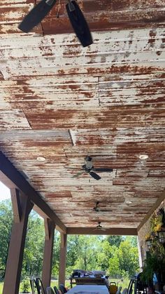 an outdoor covered patio with chairs and ceiling fans