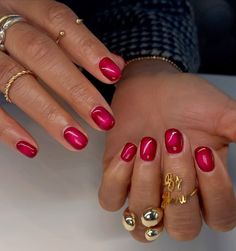 a woman's hands with red and gold manicures holding onto her hand