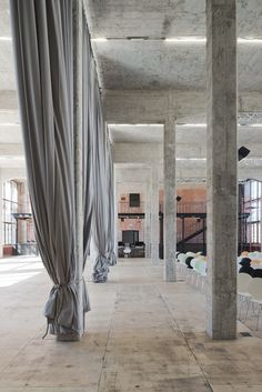 an empty room with chairs and drapes hanging from the ceiling