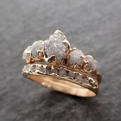 two gold rings with rough white diamonds on them