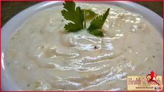 a white bowl filled with soup and garnished with parsley