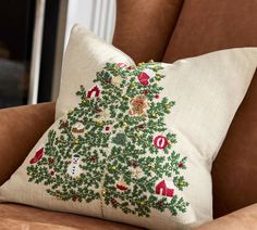 a christmas tree pillow on a brown chair