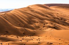 sand dunes in the desert with mountains in the background