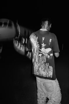 a man standing next to an airplane in the dark