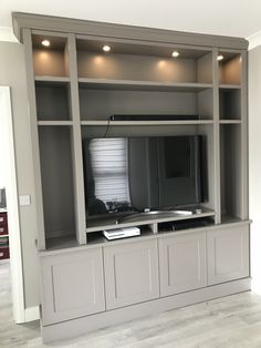 an entertainment center with built - in cabinets and flat screen tv on the back wall