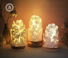 three different types of lamps with flowers on them and one is lit up in the dark