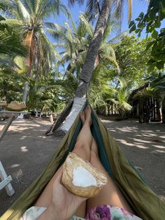 a person laying in a hammock with a piece of bread on their feet