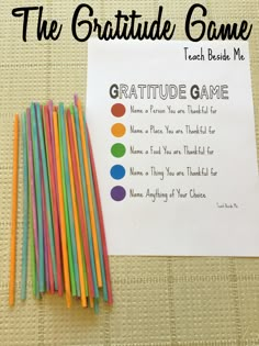 a group of colored straws sitting on top of a table next to a paper