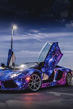 a blue and purple sports car with its doors open in the night sky filled with stars