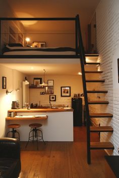 a living room with stairs leading up to the kitchen