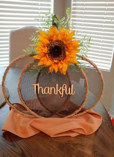 a sunflower sitting on top of a table with the word thank written in it