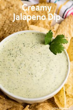 a bowl of creamy jalapeno dip surrounded by tortilla chips