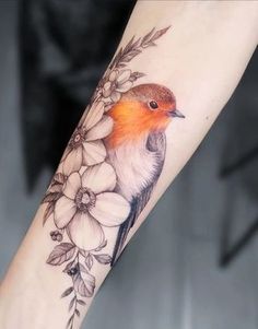 a bird sitting on top of a branch with flowers around it's neck and arm