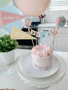 a birthday cake sitting on top of a white plate with pink frosting and decorations